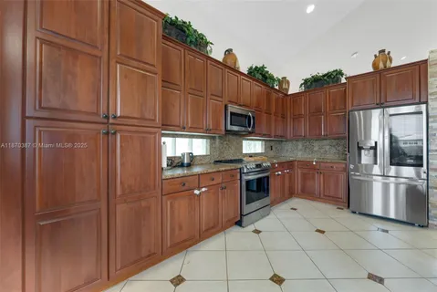 a kitchen with stainless steel appliances granite countertop a refrigerator and cabinets