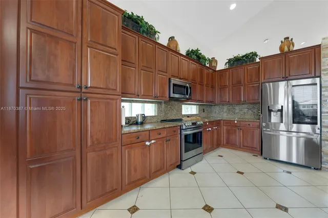 a kitchen with stainless steel appliances granite countertop a refrigerator and cabinets