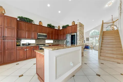 a kitchen with stainless steel appliances granite countertop a stove a sink and a refrigerator
