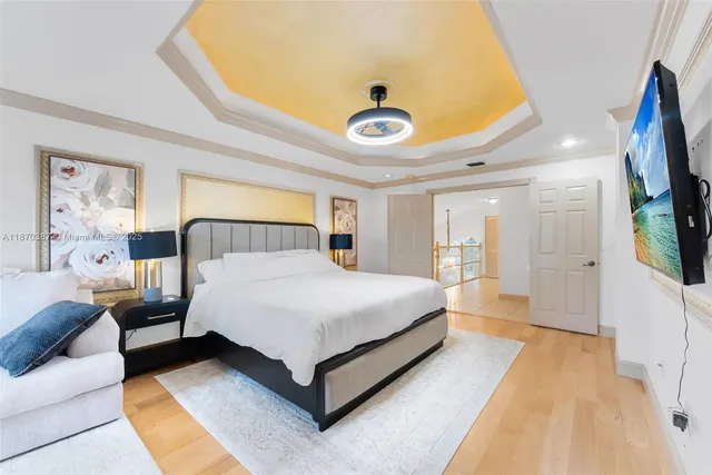 a spacious bedroom with a bed and a flat tv screen