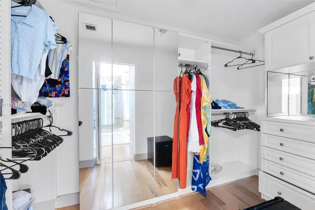 a view of walk in closet with clothes and shoes