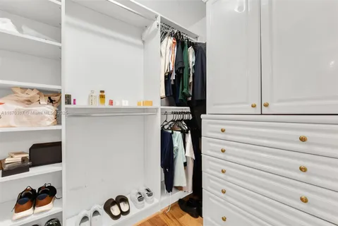 a view of walk in closet with clothes and shoes