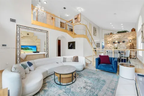 a living room with furniture a rug and a chandelier