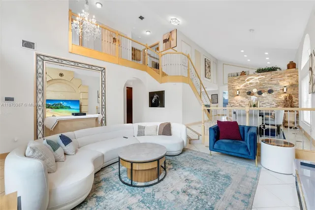 a living room with furniture a rug and a chandelier