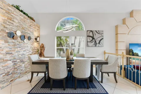 a view of a dining room with furniture a rug and wooden floor