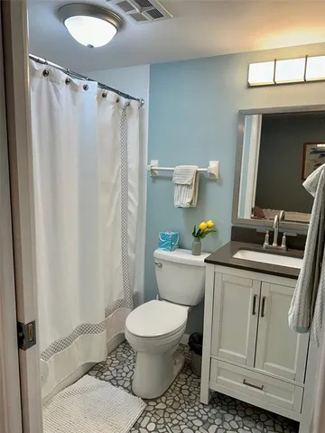 a white toilet sitting next to a bathroom sink