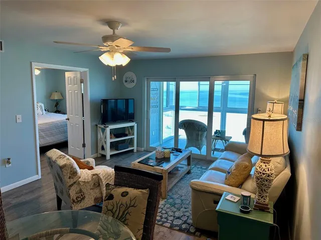 a living room with furniture a flat screen tv and a large window