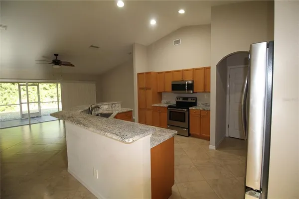 a kitchen with granite countertop a refrigerator and a sink