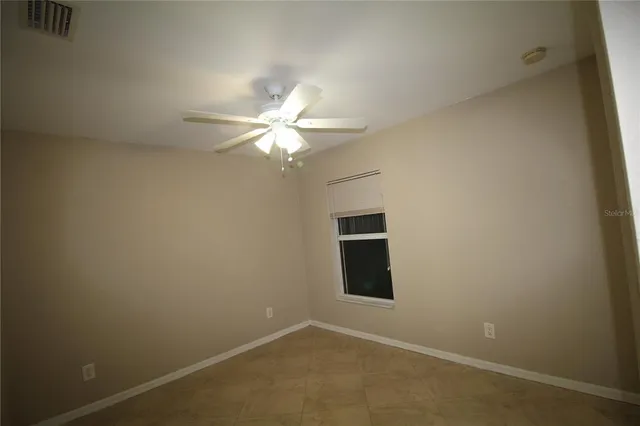 an empty room with a chandelier fan