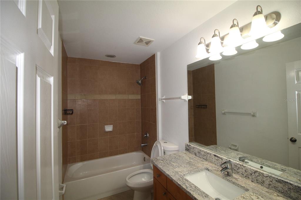 5508 Douglas Road North Port, FL 34288 - Photo 8 of 12 a bathroom with a granite countertop sink a toilet and shower