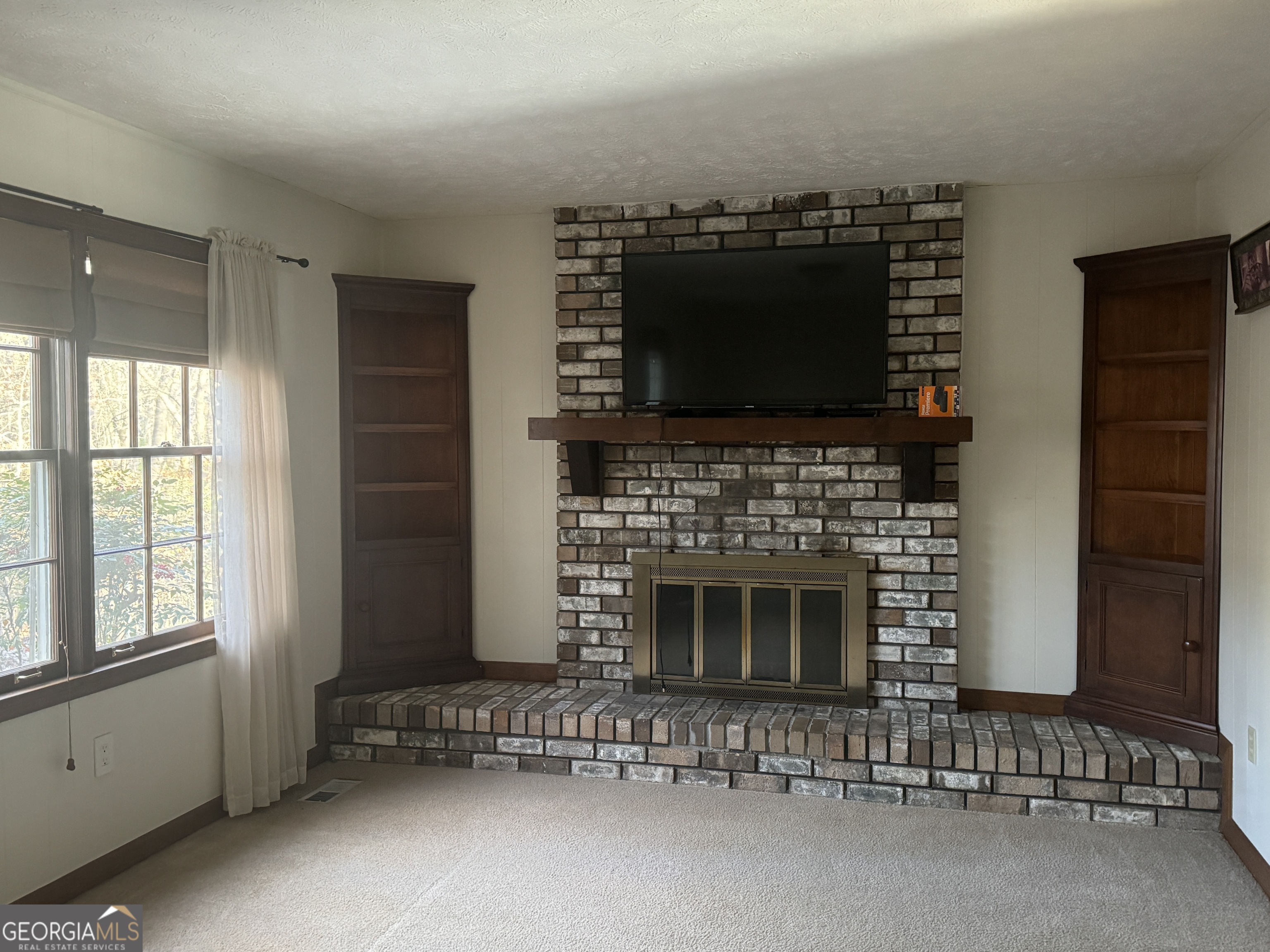 345 Caldwell Circle Athens, GA 30605 - Photo 37 of 38 a living room with a fireplace and a flat screen tv