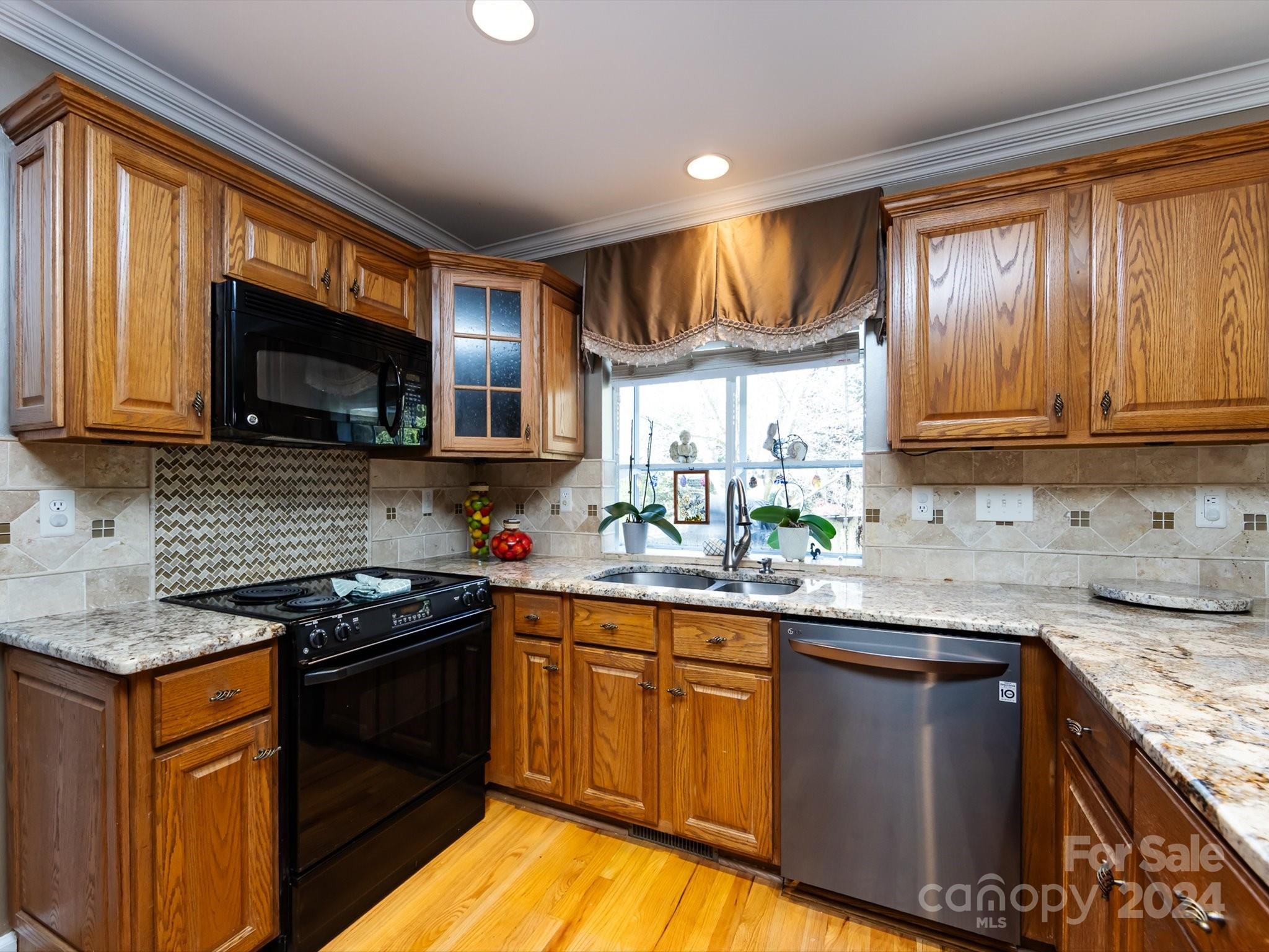 3534 Nestling Lane Fort Mill, SC 29708 - Photo 12 of 44 a kitchen with stainless steel appliances granite countertop wooden cabinets stove a sink and dishwasher
