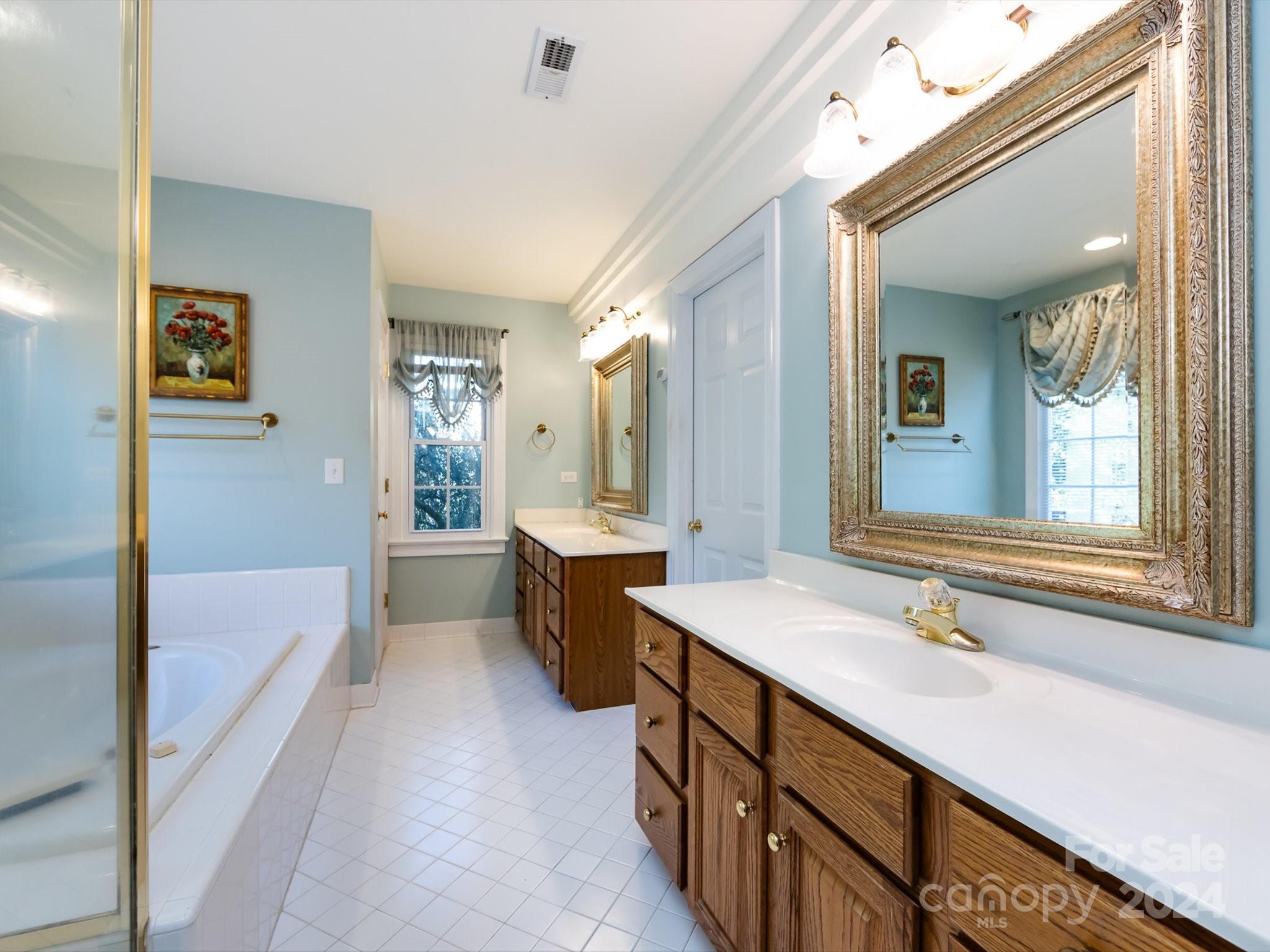 3534 Nestling Lane Fort Mill, SC 29708 - Photo 23 of 44 a spacious bathroom with a sink double vanity mirror and a bathtub