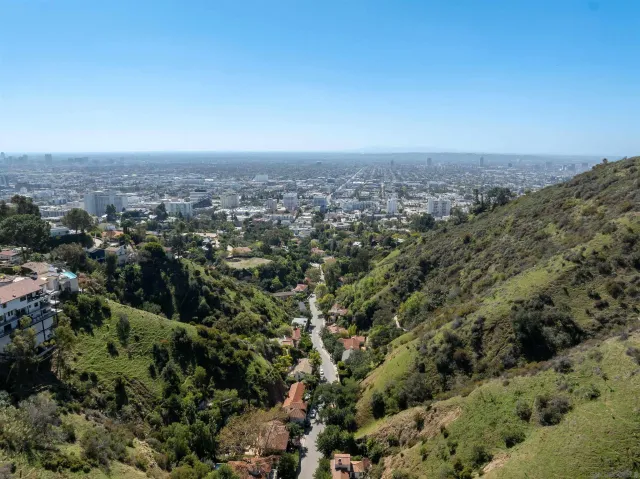 an aerial view of house with yard and mountain view in back
