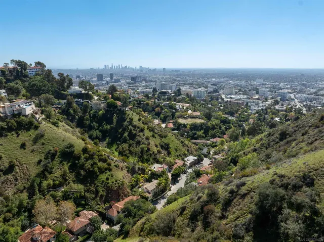an aerial view of house with yard and mountain view in back