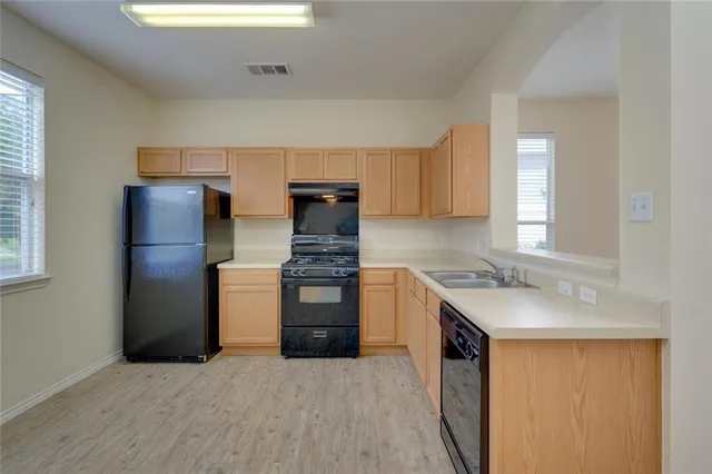 a kitchen with granite countertop a refrigerator and a sink