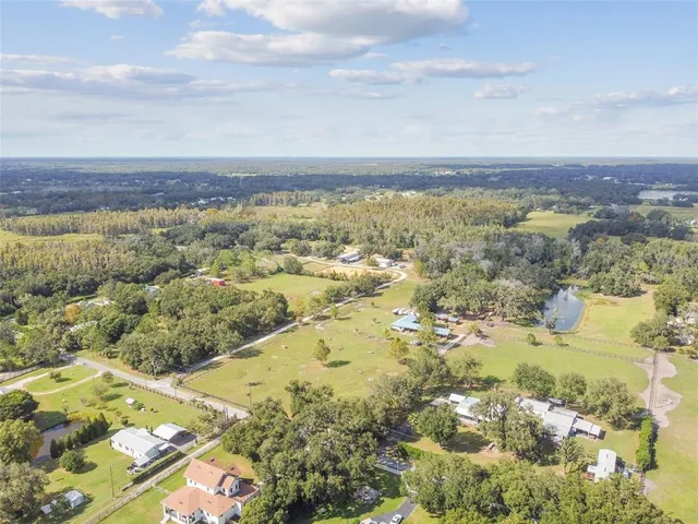 an aerial view of residential houses with outdoor space and swimming pool