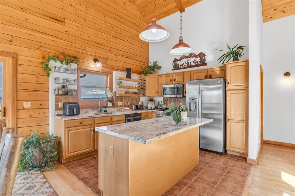1350 Mitchell Mountain Road Westcliffe, CO 81252 - Photo 11 of 45 a kitchen with stainless steel appliances granite countertop a stove a sink and a refrigerator