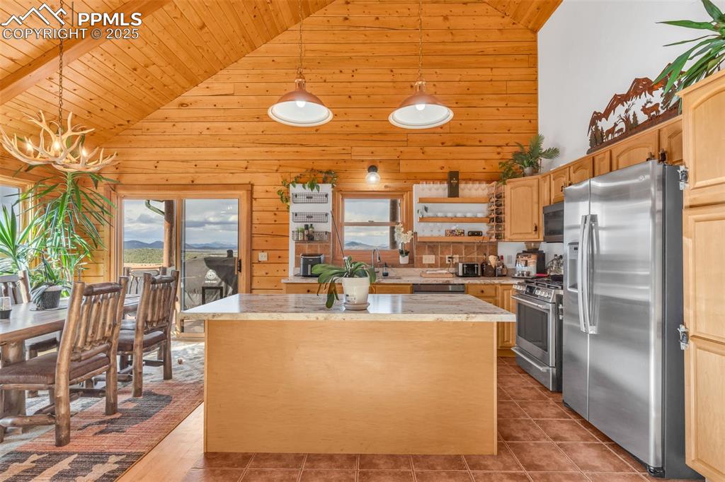1350 Mitchell Mountain Road Westcliffe, CO 81252 - Photo 12 of 45 a view of a kitchen with kitchen island a large window cabinets a sink and stainless steel appliances