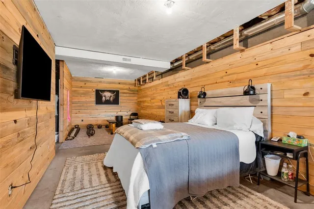 a spacious bedroom with a bed and a flat screen tv