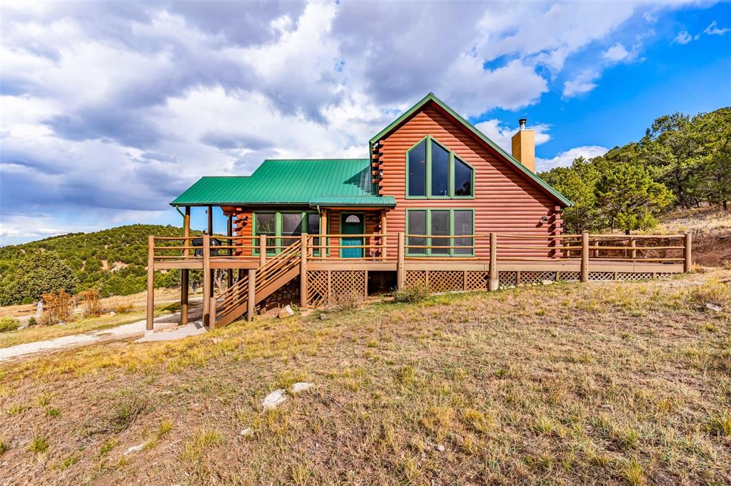 1350 Mitchell Mountain Road Westcliffe, CO 81252 - Photo 4 of 45 a view of a house with large windows and a small yard