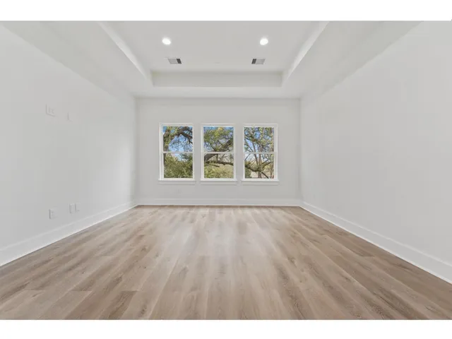 an empty room with wooden floor and window