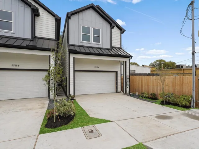 a front view of a house with a garden and garage