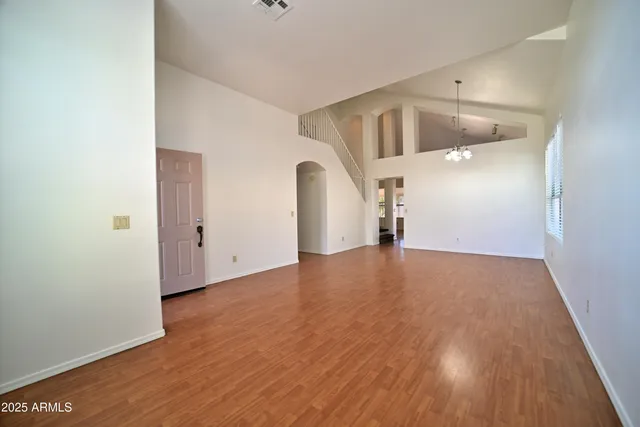 a kitchen with stainless steel appliances granite countertop a stove top oven a sink dishwasher a refrigerator and a dining table with wooden floor