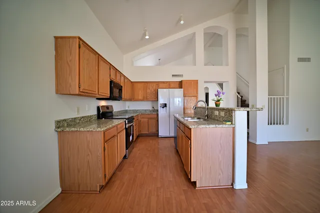 a kitchen with stainless steel appliances a refrigerator and a stove top oven