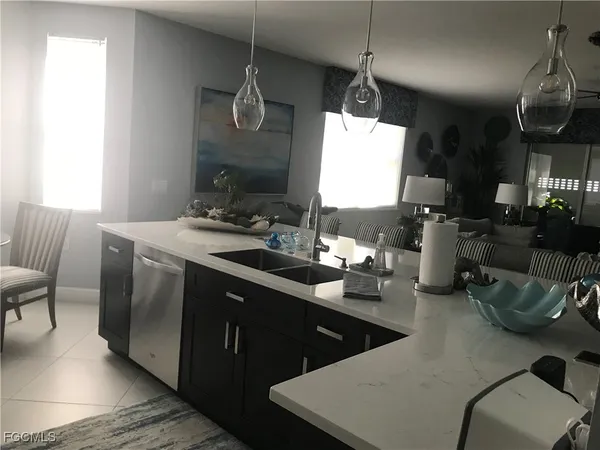 a living room with furniture kitchen view and a large window