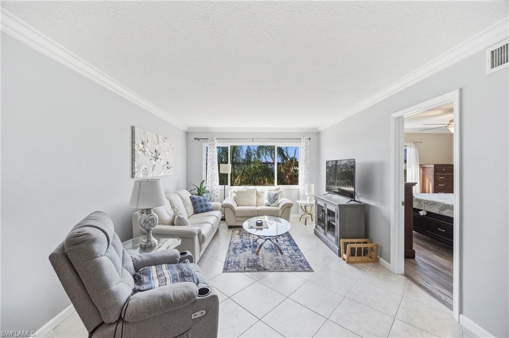 1010 Manatee Road, Unit B304 Naples, FL 34114 - Photo 2 of 24 a living room with furniture large window and flat screen tv