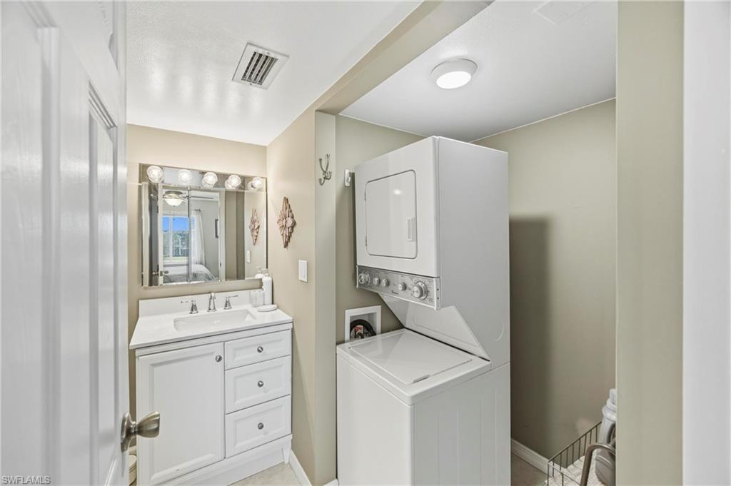 1010 Manatee Road, Unit B304 Naples, FL 34114 - Photo 24 of 24 a room with white cabinets and washer dryer