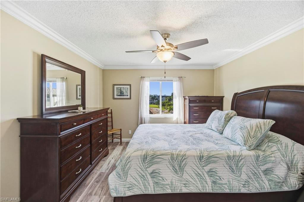 1010 Manatee Road, Unit B304 Naples, FL 34114 - Photo 4 of 24 a bedroom with a large bed and a dresser