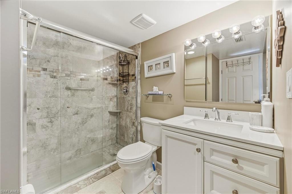 1010 Manatee Road, Unit B304 Naples, FL 34114 - Photo 5 of 24 a bathroom with a sink a toilet a mirror and shower