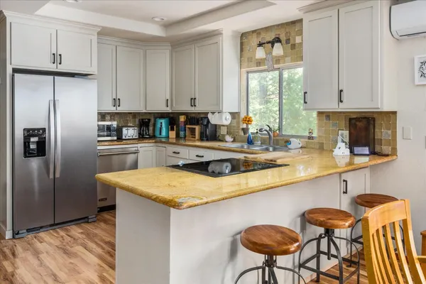 a kitchen with stainless steel appliances granite countertop a sink a refrigerator and a stove
