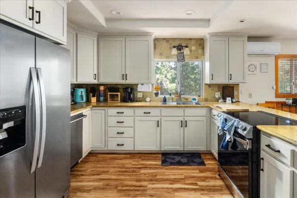 a kitchen with white cabinets and stainless steel appliances