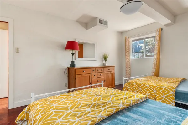 a bedroom with two bed and a dresser