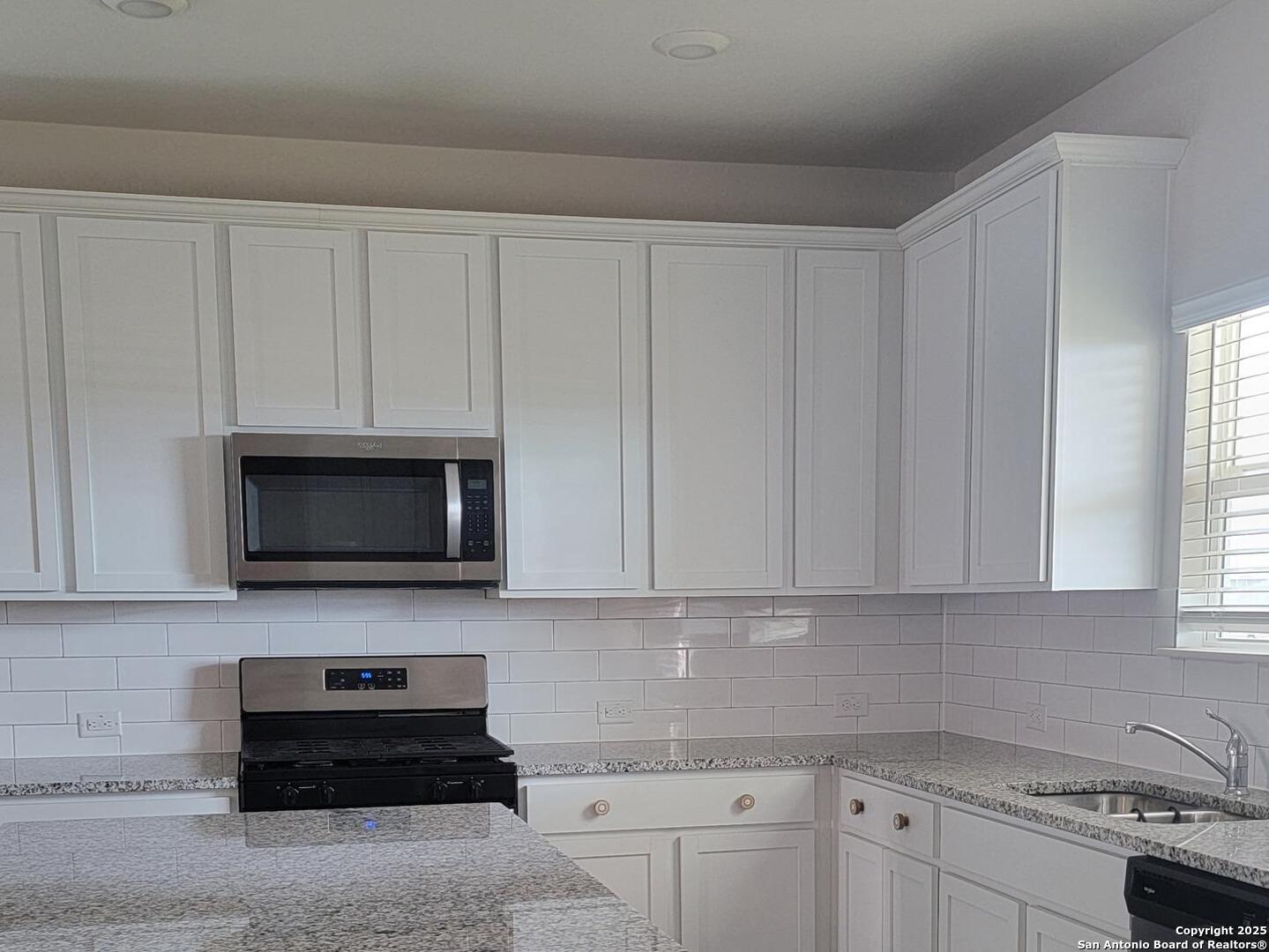609 Steele Shallows Cibolo, TX 78108 - Photo 24 of 37 a kitchen with stainless steel appliances granite countertop white cabinets a stove top oven a sink and dishwasher