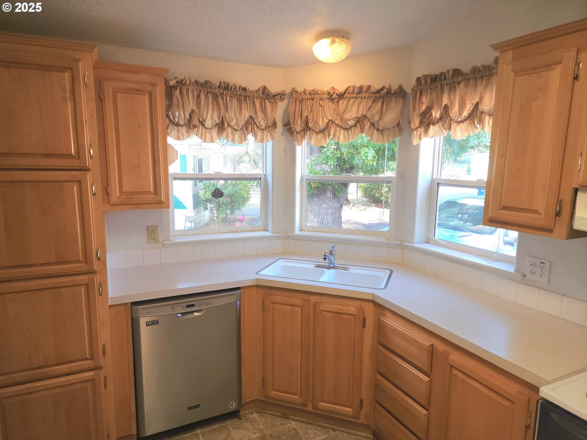 1125 58th Street, Unit 6 Springfield, OR 97478 - Photo 5 of 27 a kitchen with kitchen island a sink appliances cabinets and a large window