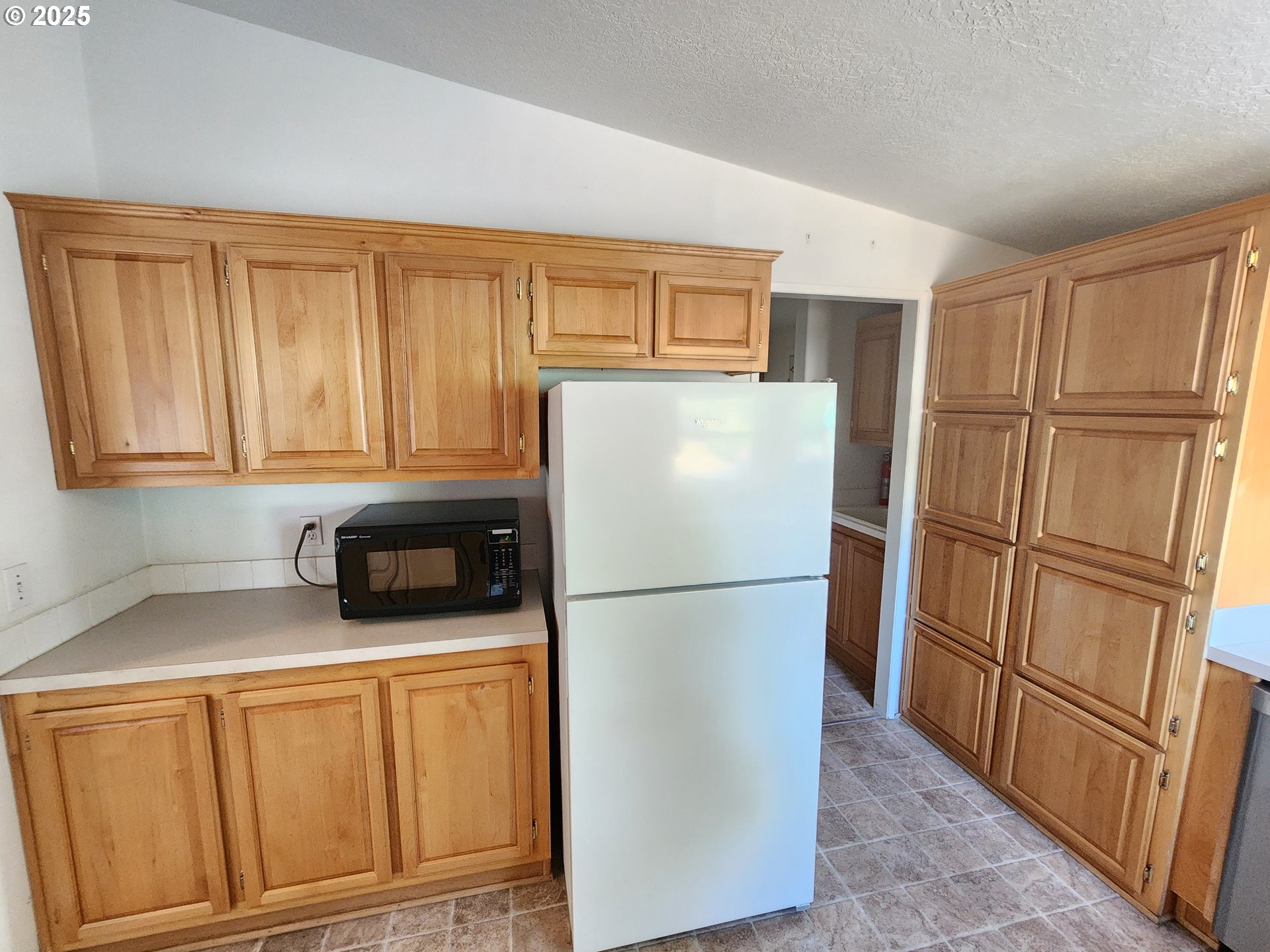 1125 58th Street, Unit 6 Springfield, OR 97478 - Photo 8 of 27 a kitchen with stainless steel appliances granite countertop a refrigerator a microwave and cabinets