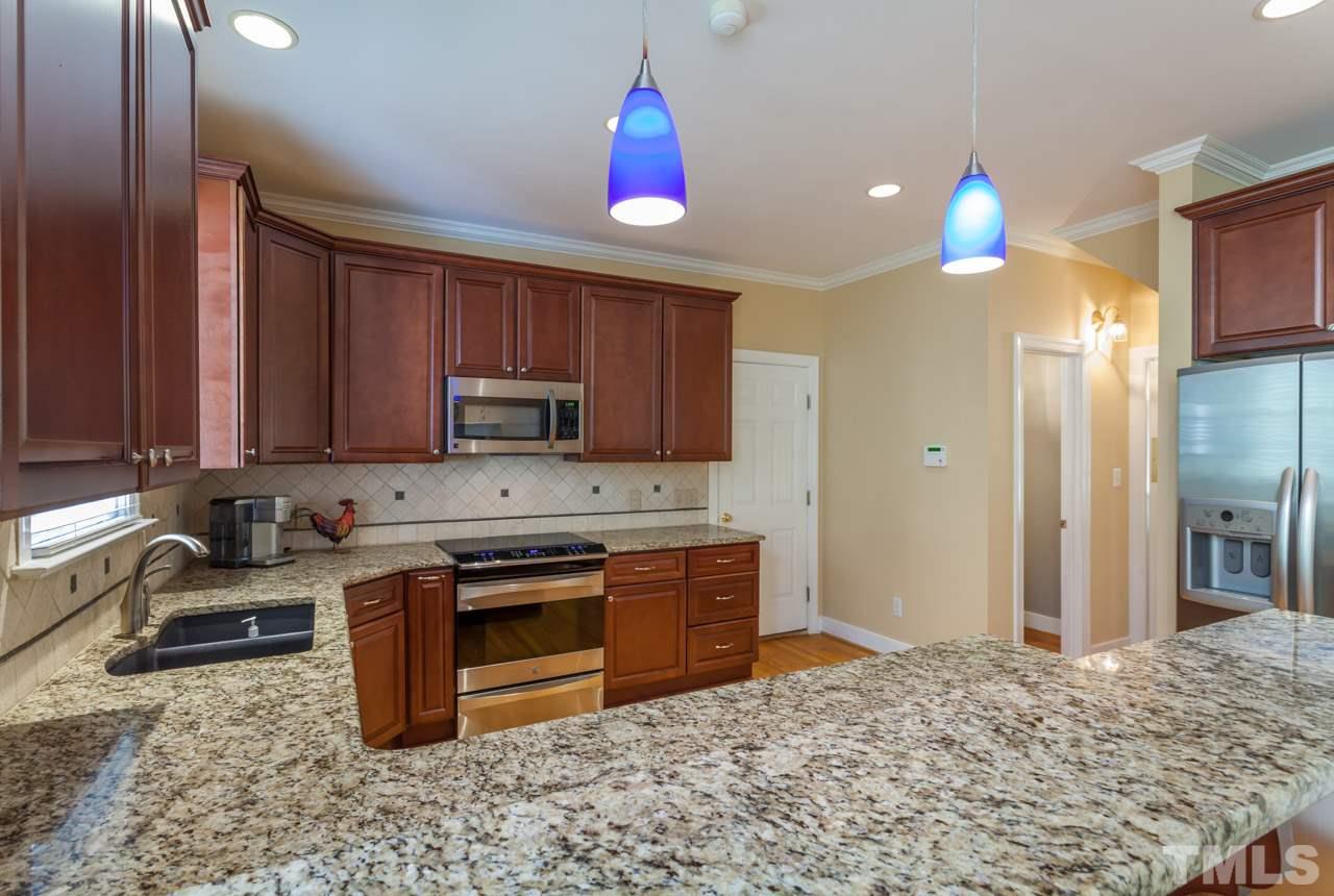 2408 Wertherson Lane Raleigh, NC 27613 - Photo 5 of 25 a kitchen with a stove a sink and a refrigerator