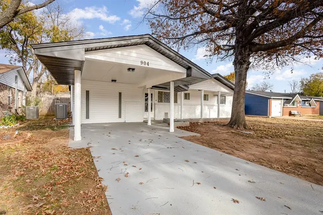 a view of a white house with a large tree