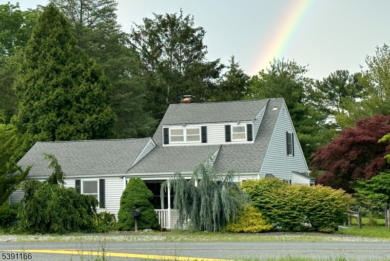 a aerial view of a house in a big yard with plants and large trees
