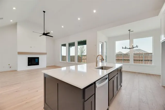 a kitchen with a center island wooden floor and a fireplace