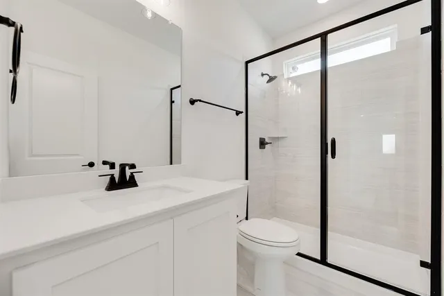 a bathroom with a sink a toilet and shower