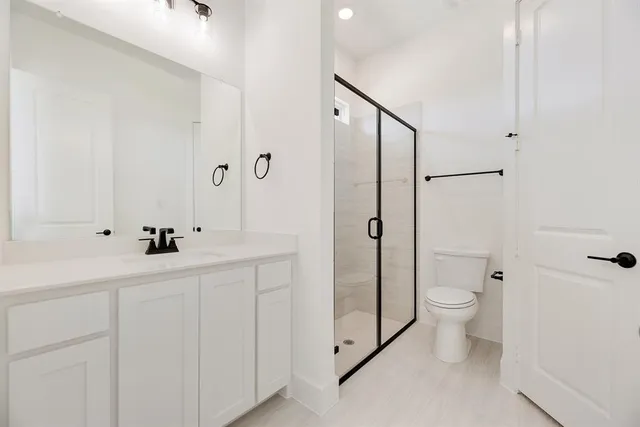 a bathroom with a sink a toilet and shower