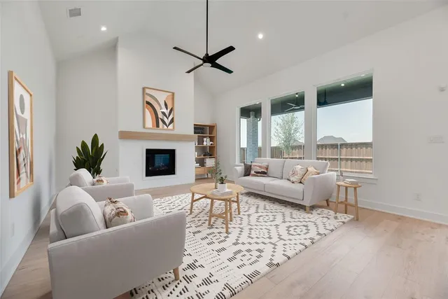 a living room with furniture fireplace and a large window