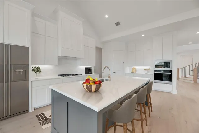 a kitchen with a sink a stove and chairs