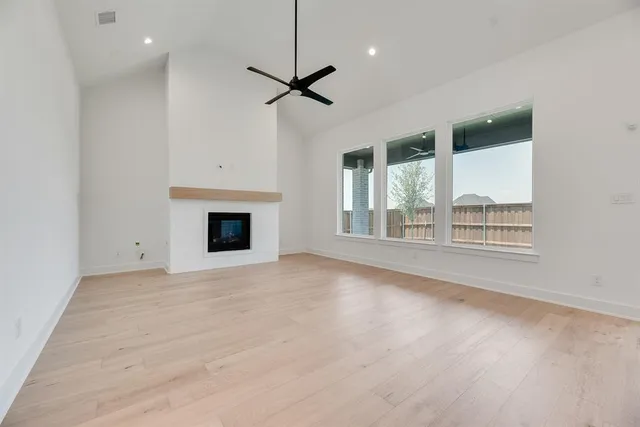 a view of an empty room with a fireplace and a window