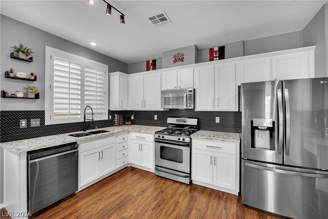 1724 Millstream Way Henderson, NV 89074 - Photo 17 of 60 Culinary creations come to life in this modern kitchen with sleek stainless appliances and durable hardwood flooring.